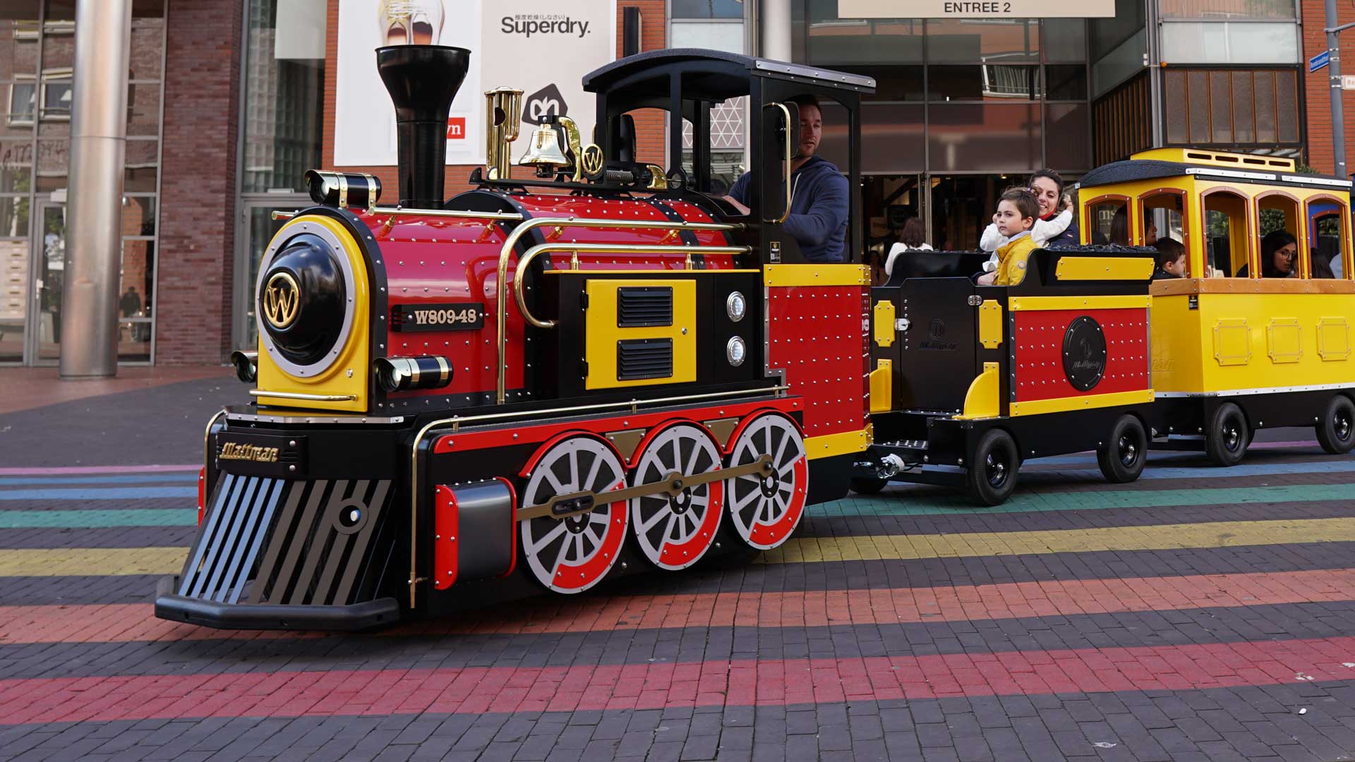Mini Express trackless train transporting families through a shopping mall